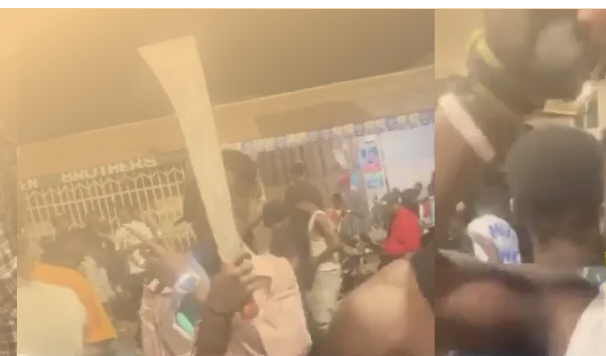 Fotograma de un vídeo de varios hombres, uno con un machete, en una calle de noche