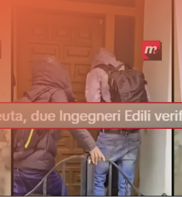 Fotograma de un vídeo de dos personas encapuchadas frente a una puerta con el texto "Ceuta, due ingegneri edili verific..."